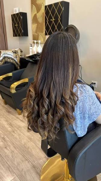 Long brunette balayage with a softly curled finish